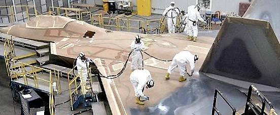 Maintenance crew painting an f15 [with aircraft maintenance stand]